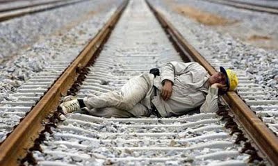 a man sleeping on a railway track